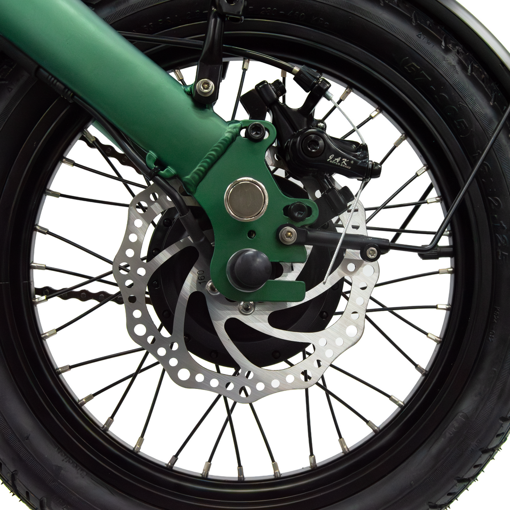 Hinterradbereich eines E-Klapprads mit Bremse, Bremsscheibe und Reifen, grüner Rahmen und schwarze Achse
