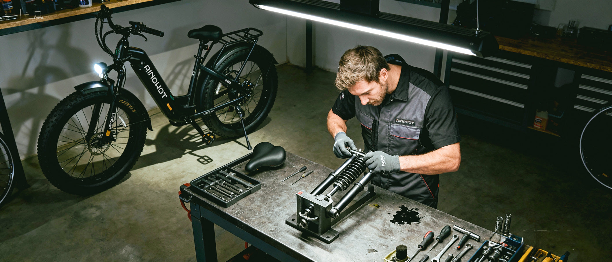 Man working on Ainohot electric bike in a workshop