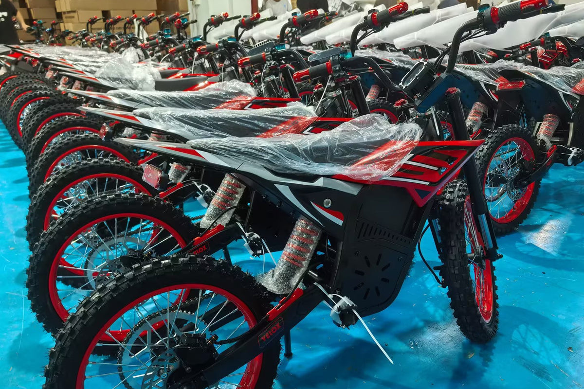 Row of Ainohot dirt bikes with red and black design on a blue floor