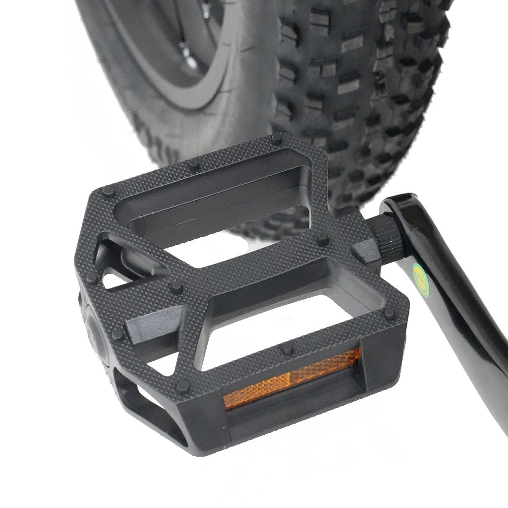 Black bike pedal with orange reflector against a white background