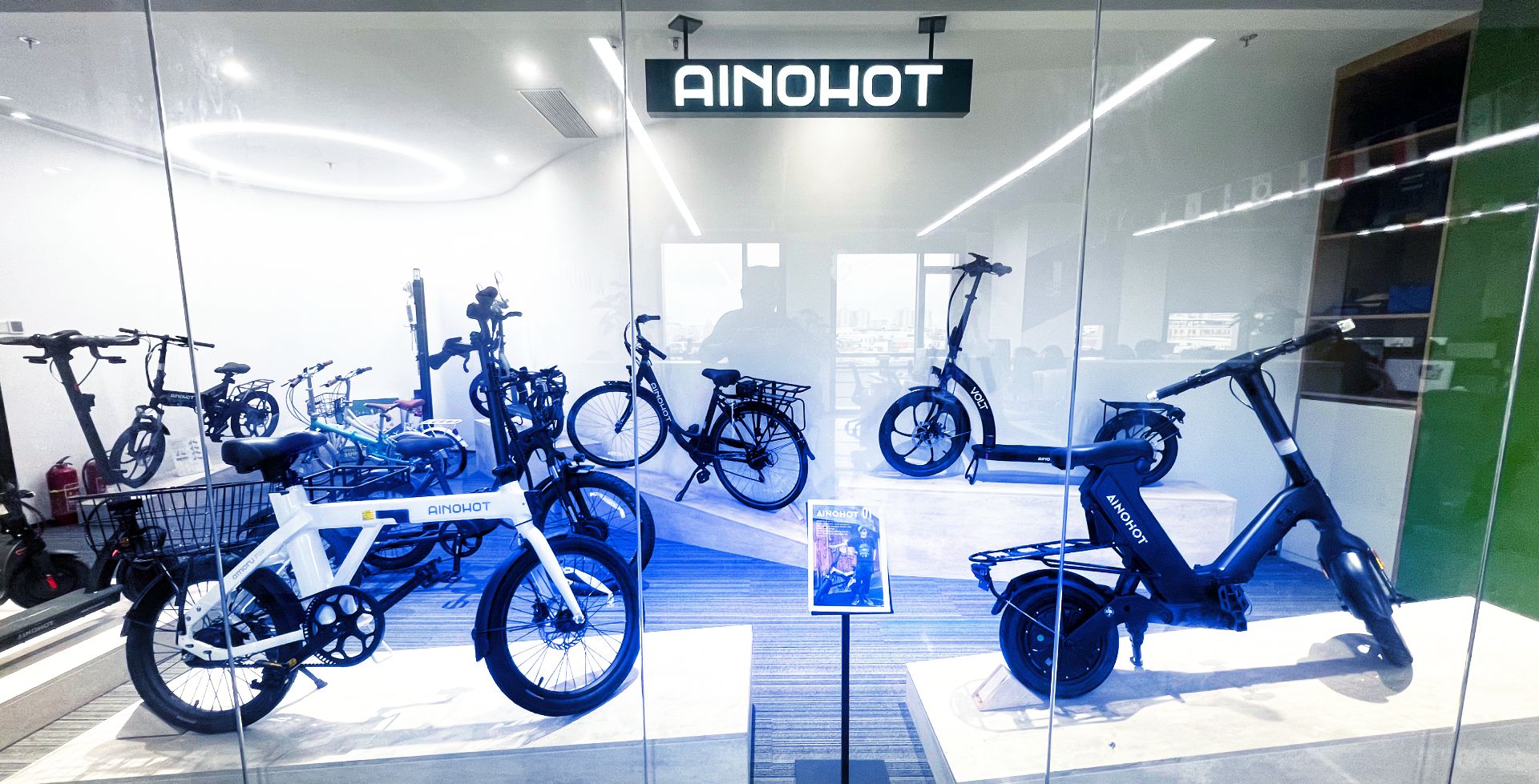 Display of electric bicycles inside a store with 'AINOHOT' branding.